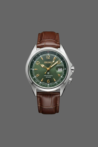 Green dial watch with gold-tone numerals and a brown embossed strap.