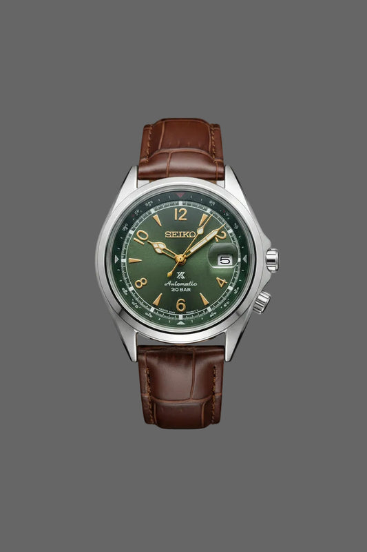 Green dial watch with gold-tone numerals and a brown embossed strap.