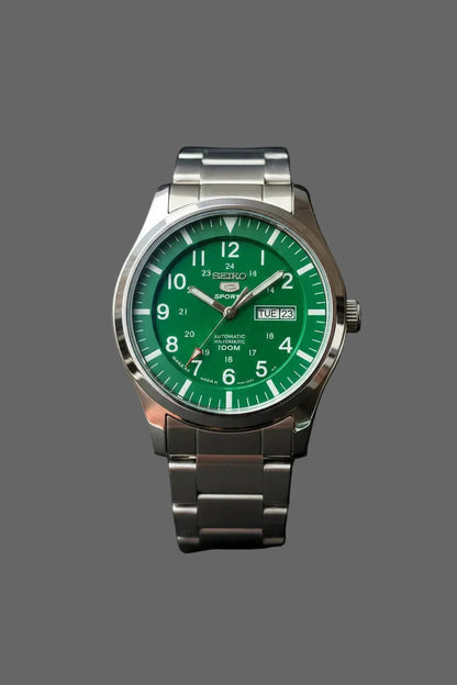 Green numeral dial watch with an inner 24-hour scale, day-date window and silver-tone bracelet.