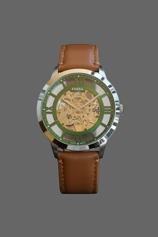 Skeleton-style watch with a green dial surround and brown stitched strap.