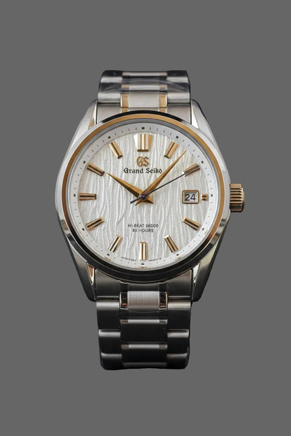 Round bracelet watch with a light textured dial and gold-tone accents.